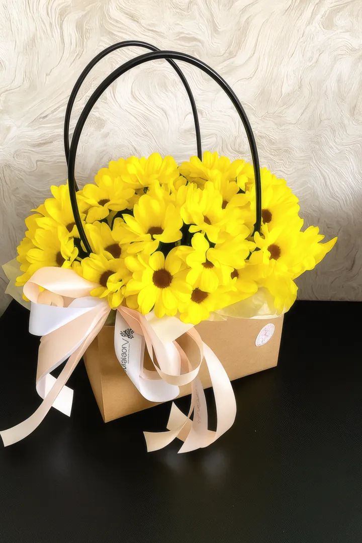 Cartera Alma Floral: margaritas amarillas en cartera kraft con lazo