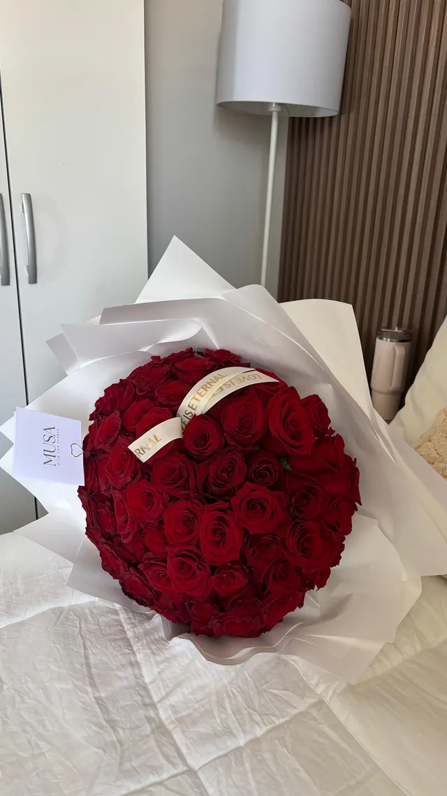 Ramo grande de rosas rojas en papel blanco