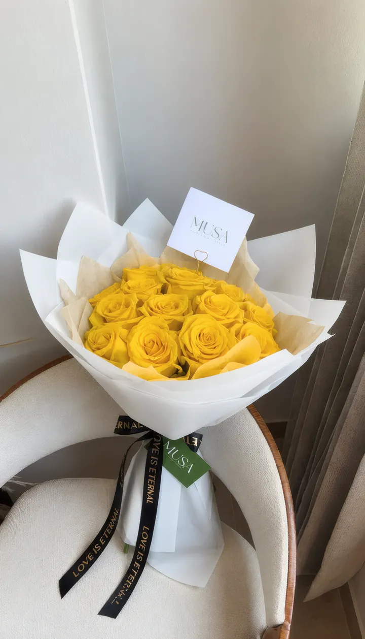 Ramo Ternura: quince rosas amarillas en papel blanco con cinta negra